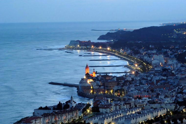 Sitges at night, with the seafront promenade and harbour lights